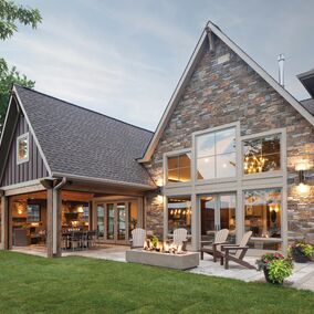 Luxury home remodel featuring Marvin windows with a stone exterior and expansive outdoor living area