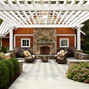 Outdoor patio featuring a white Intex trellis system, stone fireplace, and comfortable seating area