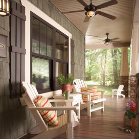 Brickmould Ply-Gem craftsman style windows on a cozy porch with white chairs, stone accents, and ceiling fans