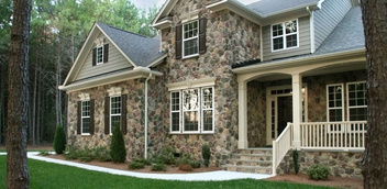 Pennsylvania fieldstone veneer on a beautiful two-story home with a wooded backdrop