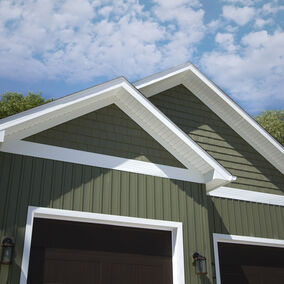 Exterior of home with green CedarMax Willow siding and white trim by Provia. There are two black light fixtures on the side of the garage door.