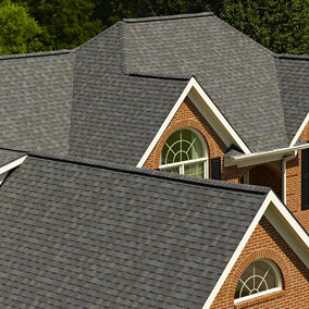 Landmark Driftwood roofing shingles installed on a multi-gabled brick home