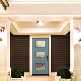 A front porch with large white columns framing and a Therma-Tru door with a modern design and three glass panels