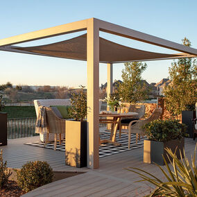 Elegant Trex deck with a modern pergola, stylish outdoor seating, and greenery overlooking a scenic view