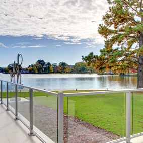 Scenic lakeside view from a modern deck with Westbury glass panel railing