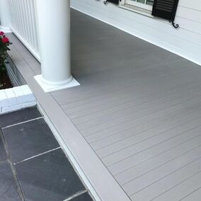 Front porch with Wolf Serenity Porch flooring, showcasing a clean, modern look with classic white columns